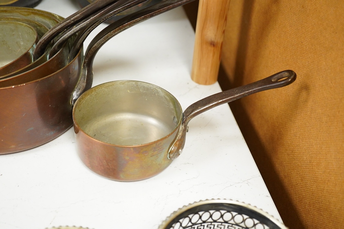 A graduated set of five copper saucepans